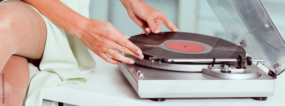 partial view of pin up girl putting vinyl record on record player partial view of pin up girl putting vinyl record on record player