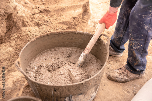 Mason kneads cement mortar for pouring concrete screed