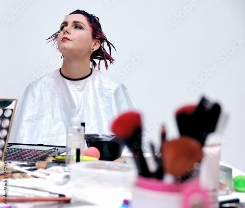 Beautiful girl with violet hair on white background master in make-up.