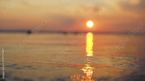 Slow motion shot of beautiful mystic sunset on a lake of Uvildy Russia. Waves roll on camera. photo