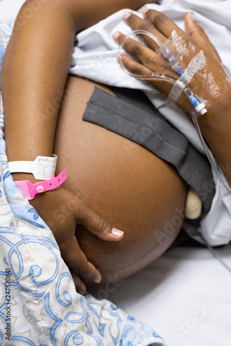 An image of a pregnant lady lying in a hospital bed with her baby's heart beat being monitored while she waits for her cesarean section.