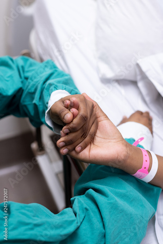 An image of a doctor holding a patients hand.