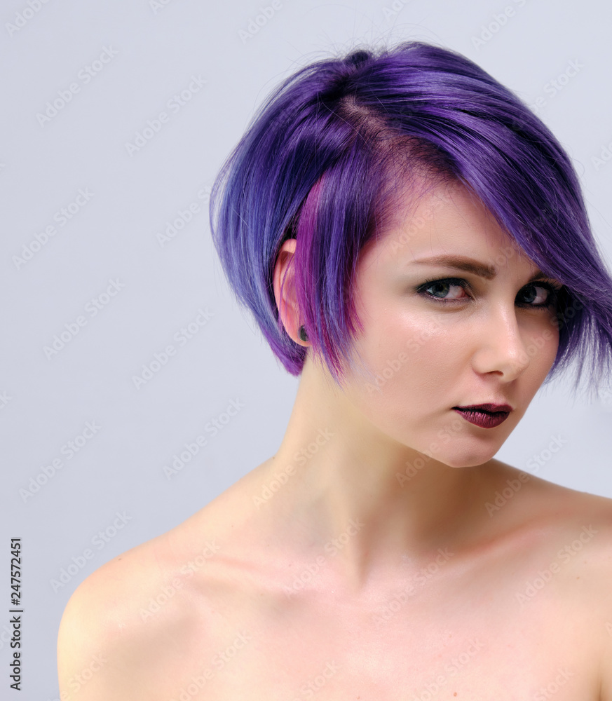 A beautiful, sexy girl with purple hair and a short haircut sits in the  middle of the photo with a white background Stock Photo | Adobe Stock
