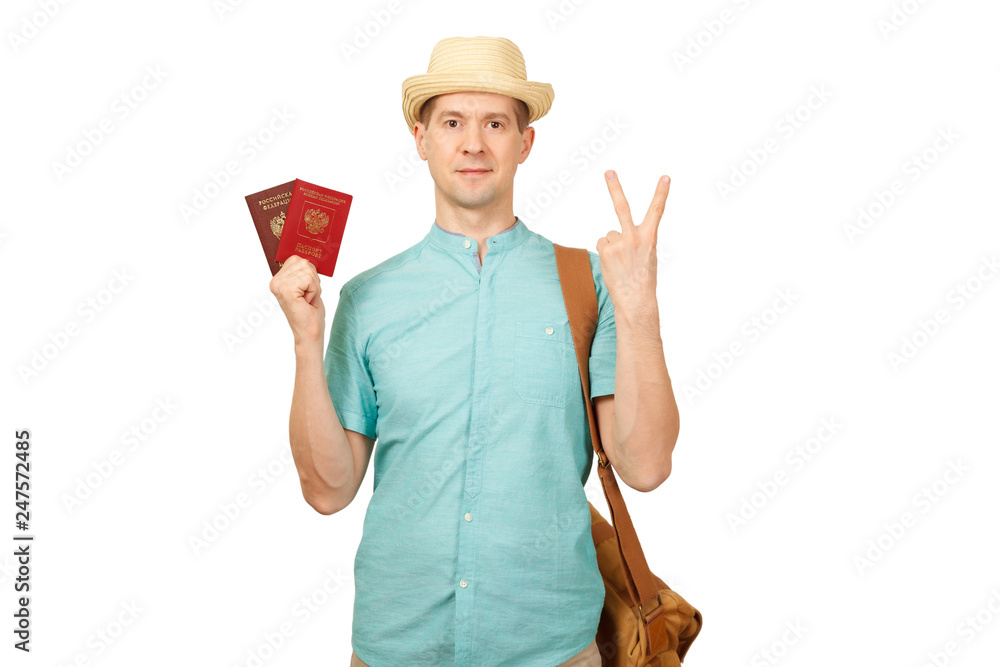The man with the international passport, in a summer shirt, a hat and a traveling bag. Shows two fingers, gesture - a victory The man with the international passport, in a summer shirt, a hat and a traveling bag. Shows two fingers, gesture - a victory