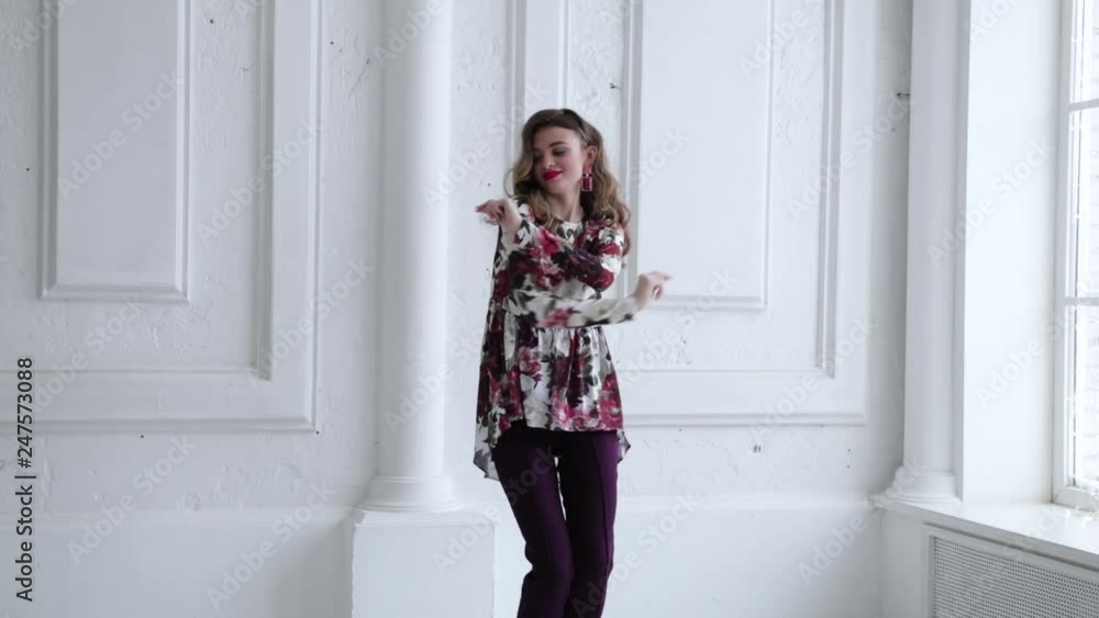 Young funny girl dancing and laughing. Girl with blond hair dancing on a white background. Girl spinning and having fun. Slow motion Young funny girl dancing and laughing. Girl with blond hair dancing on a white background. Girl spinning and having fun. Slow motion