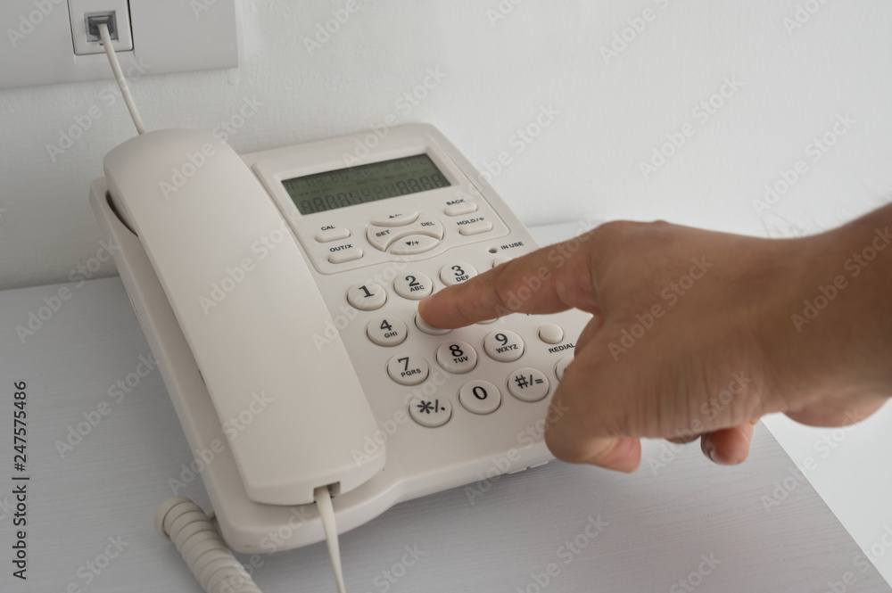 Man finger push home telephone button. Man finger push home telephone button.