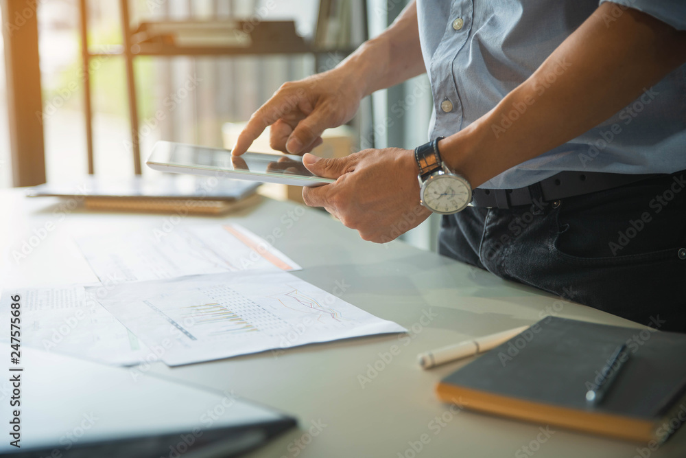 Businessman's hand pointing at business document during discussion at his working place in office. Businessman's hand pointing at business document during discussion at his working place in office.