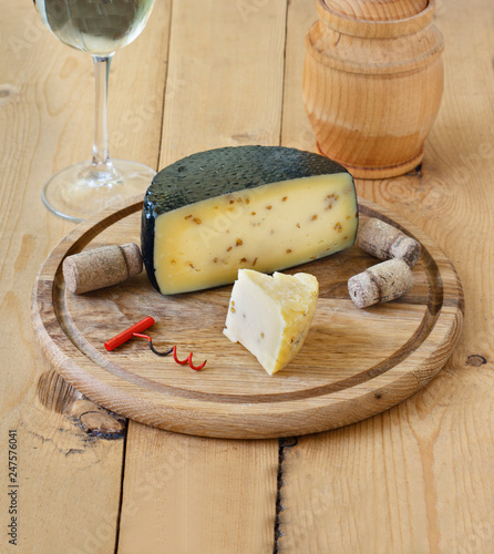 Kachotta cheese on a wooden board on a wooden background with wine in a glass and honey photo