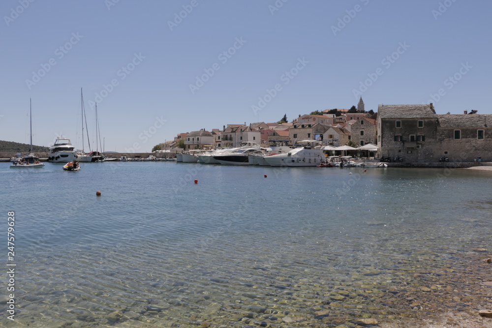View of the marina and the old town of town in Primosten. Sailboats, yachts on the Adriatic Sea. Beautiful weather. Sunny, hot, summer day on the Croatian coast. Mediterranean, riviera, Croatia.