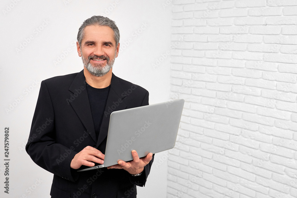 Man smiling, posing with notebook in studio. Man smiling, posing with notebook in studio.