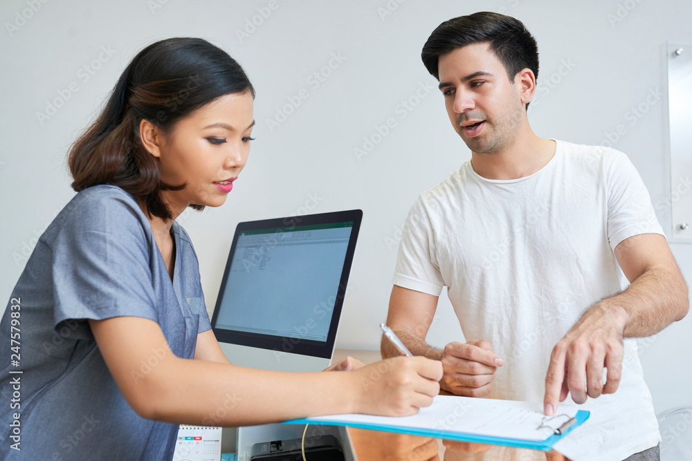 Man consulting with receptionist Man consulting with receptionist