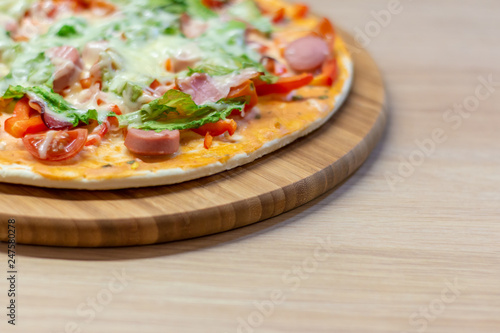 Side view homemade pizza with copy space on bright background with selective soft focus.