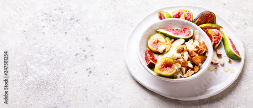 Yogurt Greek with figs Almond and Mead. Healthy Food Concept. Useful breakfast on the stone background.Diet Nutrition .Copy space for Text.Banner
