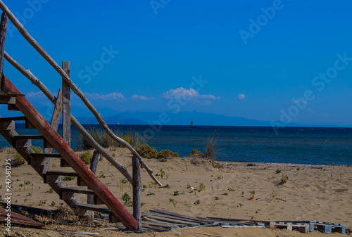 wooden stair on a sandy beach cabon near the ocean summer day