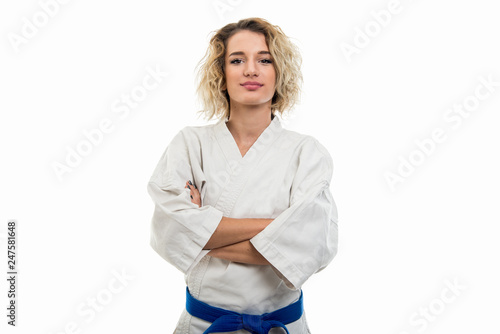 Portrait of female wearing martial arts uniform standing with arms crossed