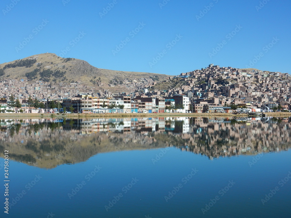 the town of Puno reflected on Titicaca lake, Peru