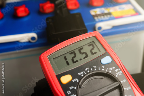 Canvastavla Checking voltage battery of ca with volt meter 12 v. dc