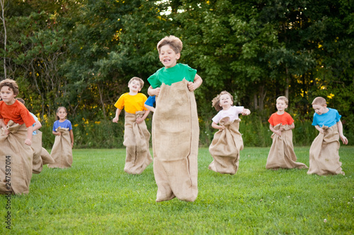 Happy Kids Having Potato Sack Race Outside