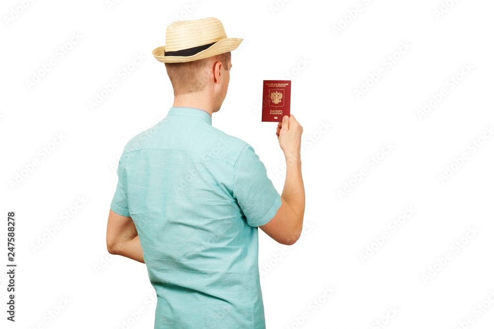 The man looks in the opened international passport. in a summer shirt, a hat. The rear view, from a back The man looks in the opened international passport. in a summer shirt, a hat. The rear view, from a back