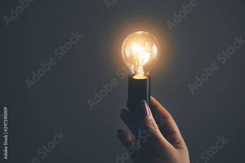 man hand light bulb on dark background