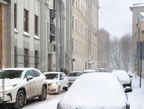 car traffic at narrow street city in snowfall © Ekaterina