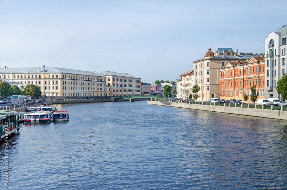 Fontanka river embankment, the English Bridge and tourist boats in St.Petersburg, Russia