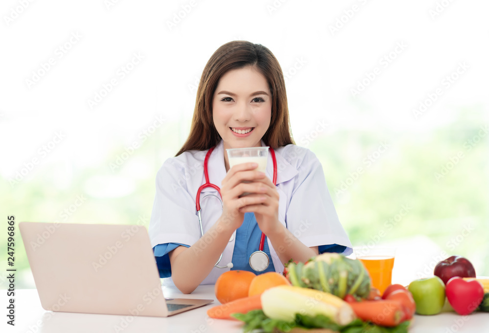 Young Asian Nutritionist Holding a Glass of Milk Showing about Nutrition Dietary , Healthy and Healthcare Concept Young Asian Nutritionist Holding a Glass of Milk Showing about Nutrition Dietary , Healthy and Healthcare Concept