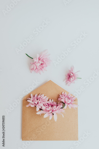 Craft envelope full of flowers. Flat lay on white background © Igor