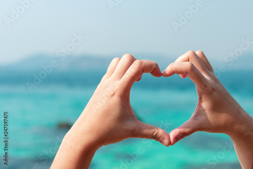 Two hands make "heart symbol" with multi-color tropical Blue sea background,Love and Valentines concept,Love the environment © miraclebuggy