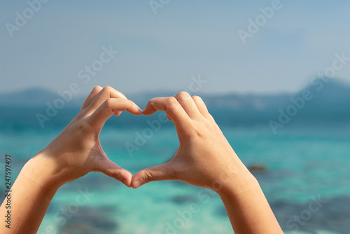 Two hands make "heart symbol" with multi-color tropical Blue sea background,Love and Valentines concept,Love the environment © miraclebuggy