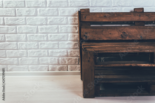 Wooden bench of flying against a white brick wall