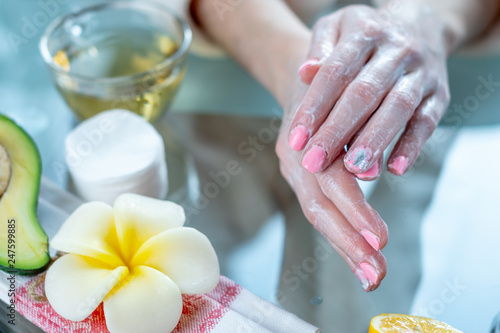 Woman applying the cream on hands nourishing them with natural cosmetics. Concept of hygiene and care for the skin