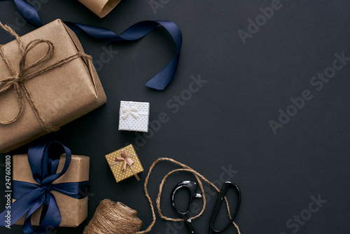 Creative gift boxes on dark background. Wrapping with brown paper