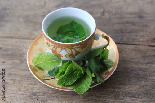 leaves of green mint and a cup of tea