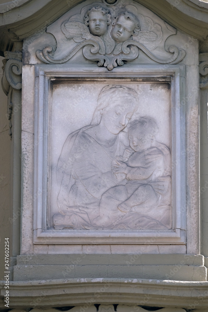 Virgin Mary with baby Jesus, relief on the house facade in Florence, Italy