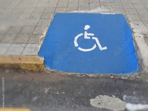 Ramp of curb in the sidewalk for locomotion of wheelchair with icon designed