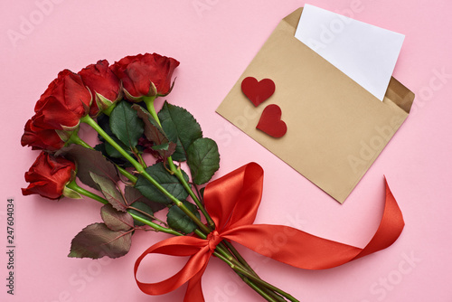 True love. Envelope with paper note, bouquet of roses with red ribbon