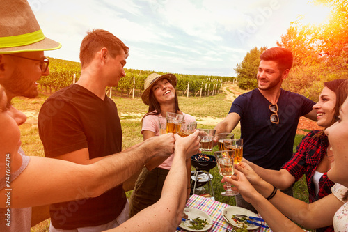 happy people celebrate birthday of their friends during picnic in the vineyard