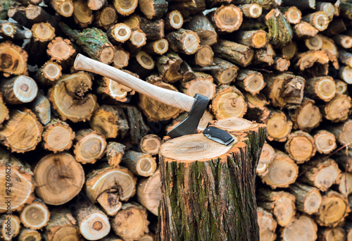 axe and jackknife case on the stump, firewoods on the background photo