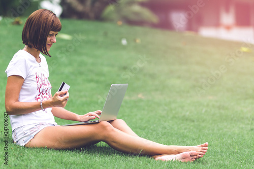 Woman online shopping concept. Woman in the green park with modern laptop. Bali island. © belart84