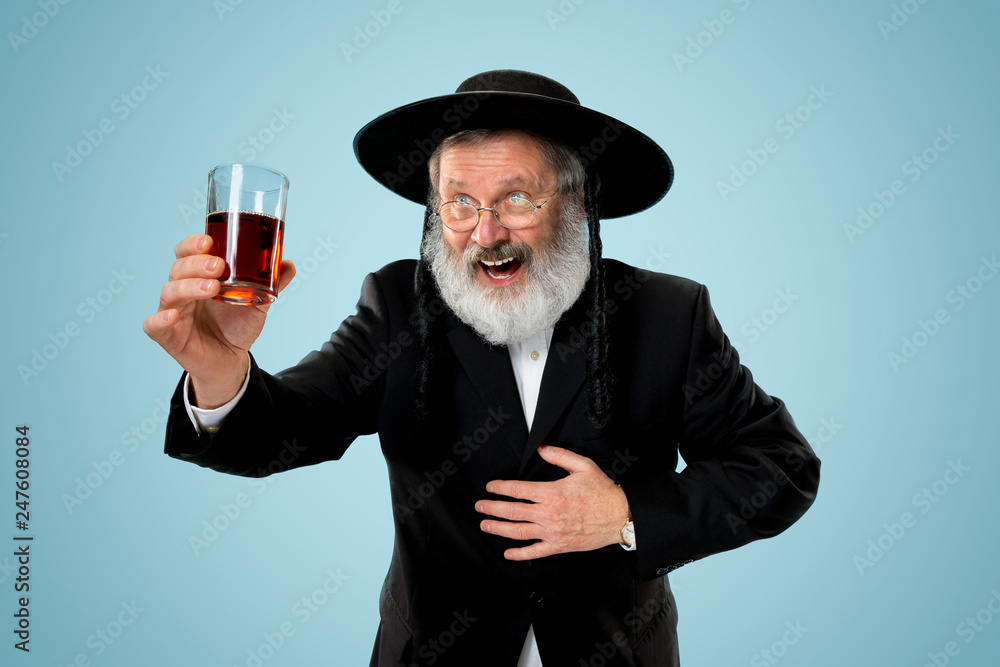 Portrait of old senior orthodox Hasdim Jewish man with kosher wine at Jewish festival of Purim at studio. The purim, jewish, festival, holiday, celebration, judaism, pastry, tradition, cookie Portrait of old senior orthodox Hasdim Jewish man with kosher wine at Jewish festival of Purim at studio. The purim, jewish, festival, holiday, celebration, judaism, pastry, tradition, cookie