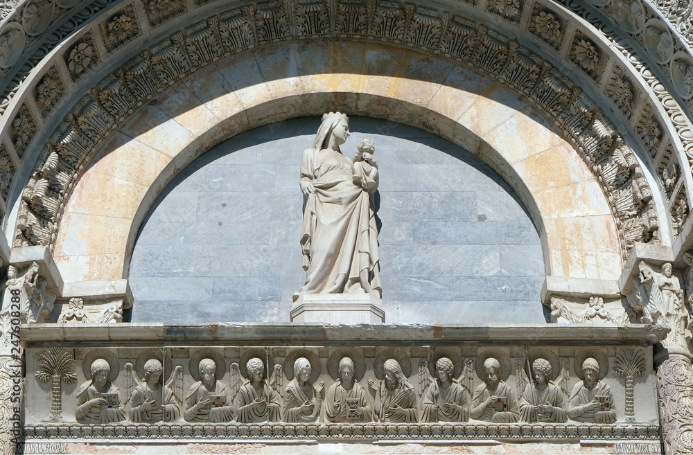 Virgin Mary with baby Jesus above Entrance Door of Cathedral Church Baptistery in Pisa, Italy