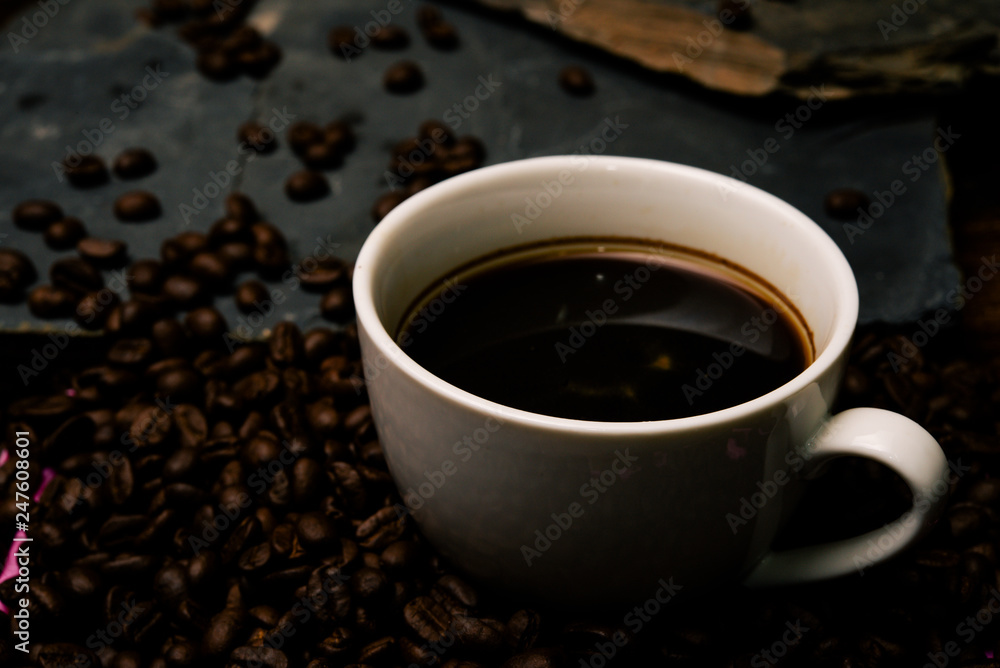 Cup of coffee with smoke and coffee beans on table with coffee beans. Cup of coffee with smoke and coffee beans on table with coffee beans.