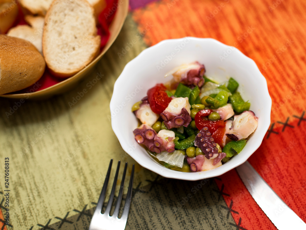 octopus salad with peppers and green peas in a bowl octopus salad with peppers and green peas in a bowl