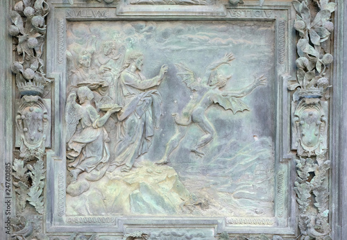 Jesus Christ tempted by Devil in the desert, sculpture work from Giambologna's school, collocated in the left portal of the Cathedral St. Mary of the Assumption in Pisa, Italy