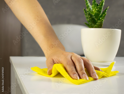 Image view above, flat lay detergent. The concept of Service for cleaning apartments and premises, cleanliness. Hand rubs the dust off the table. Housewife, maid cleans the house