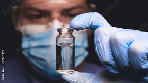 Laboratory worker scientist laboratory assistant tests chemicals for reactions in test tubes, interfering with different substances and obtaining a visual reaction. Concept of: Science, Chemistry. photo