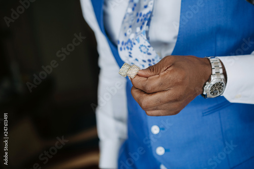 Handsome African American man in blue suit gets ready for a wedding