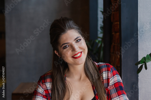 Beautiful and sexy girl sitting by the window in a cafe and smiling. © combo1982