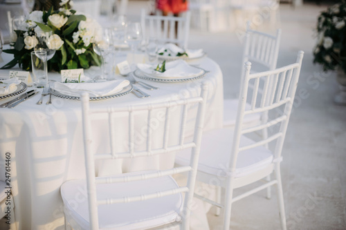 Classic white set of wedding dinner table. White bouquets as a centerpiece
